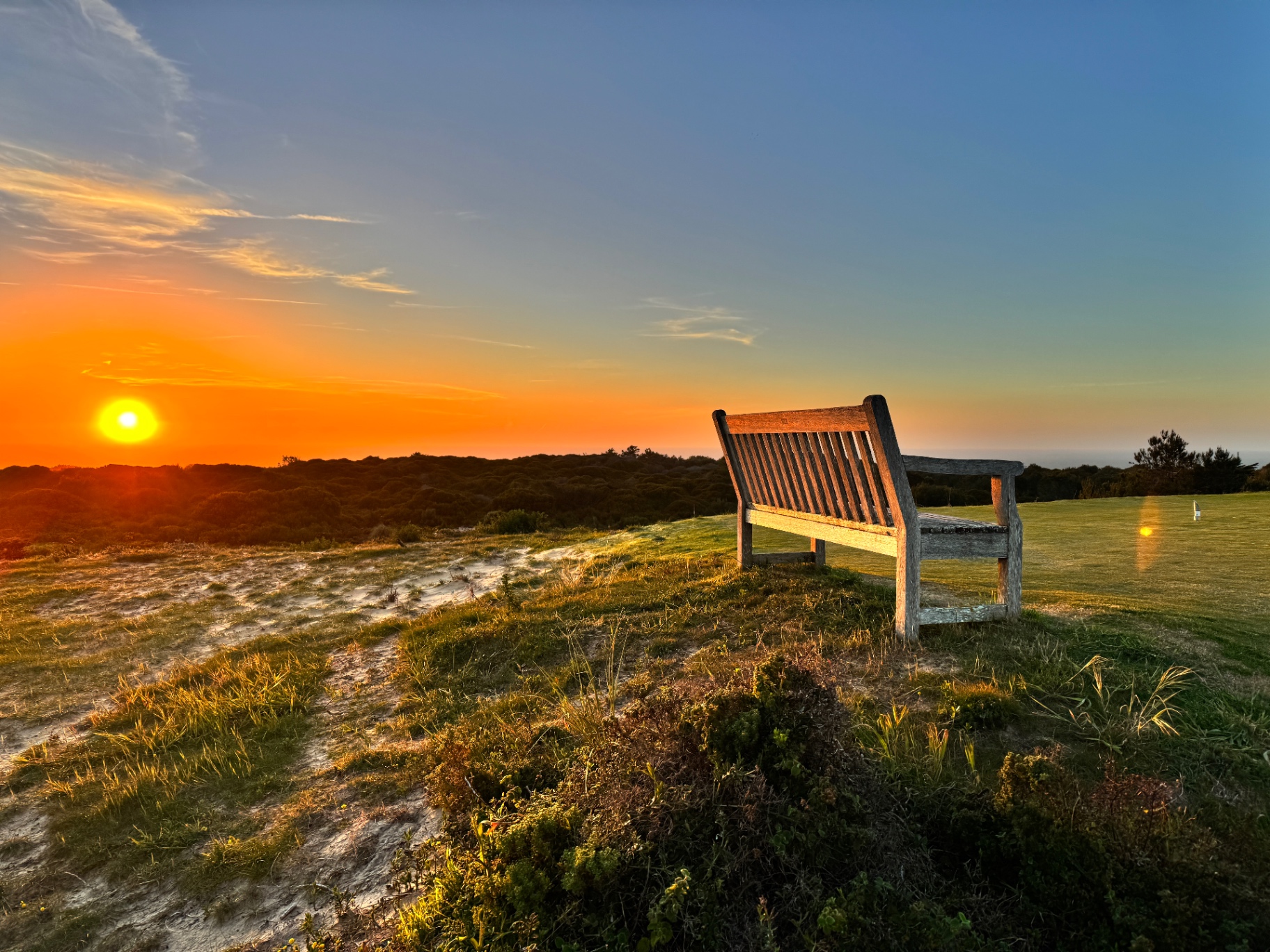 Sunset over a bench in the dunes